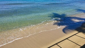 Una playa con agua cristalina y una orilla arenosa.