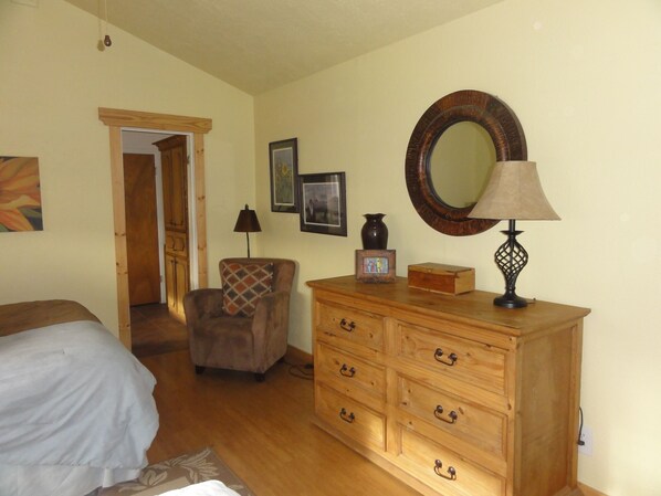 A bedroom with a bed, wooden dresser, and a mirror. - Spanish Ranch on the Arkansas River- enjoy the rushing river from the Hot tub! (Howard)