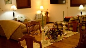 Une table à manger décorée avec des bougies, un vase de fleurs et un set de table.