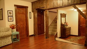 Un salon spacieux doté d’un parquet, d’un canapé, d’une table basse et d’un escalier menant à un autre niveau.