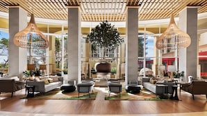 A spacious lobby with a central seating area, large windows, and modern pendant lighting.
