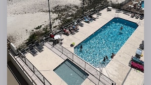 A pool area with a view of the beach and ocean.