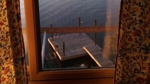 A room with a view of a lake through a window with floral curtains. - Love Sunsets?   Glory in a natural, cozy,  rustic setting (Huddleston)