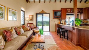 Un salón amplio con sofá, mesa de centro y vistas al exterior.