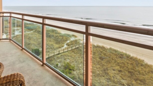Een balkon met uitzicht op de oceaan en een weg.