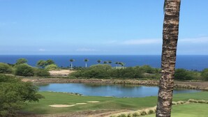 A golf course with a pond, palm trees, and a view of the ocean. - Uninterrupted Sunset, Ocean and Golf Course Views from our Lanai and Interior (Kamuela)