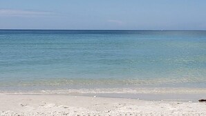 En strand med klart vand og en sandet kyst.