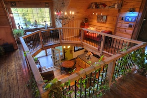 A wooden cabin with a balcony, a dining area, and a kitchen. - adirondack style all season lodge/resort on a natural glacier pond- SPECIAL RATE (Granville)