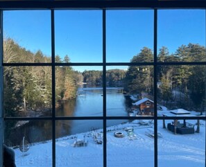 A cabin with a view of a river and forest, surrounded by snow. - adirondack style all season lodge/resort on a natural glacier pond- SPECIAL RATE (Granville)