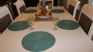 A dining table with a fruit bowl, two glasses of green drink, and woven placemats. - Beautiful Desert Escape w/private pool just north of Scottsdale. Special rates!  (Cave Creek)