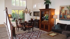 A living room with a dining area, a staircase, and a large window. - Beautiful Desert Escape w/private pool just north of Scottsdale. Special rates!  (Cave Creek)
