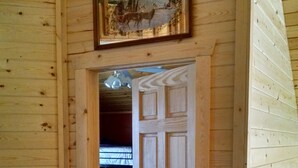Interior de madera con una puerta que da a un dormitorio.