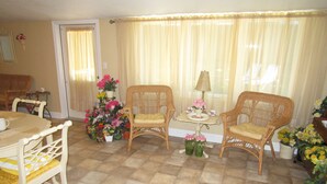 A dining area with a table and chairs, a small table with a lamp, and a window with curtains. - Elegant & Spacious Home!! 5 Bed & 3 Bath, 15 min. to U of O, Sleeps 14, 174.00 (Creswell)