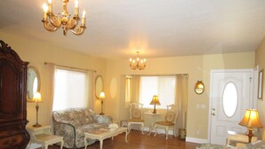 A living room with floral-patterned sofas, a wooden coffee table, and a chandelier. - Elegant & Spacious Home!! 5 Bed & 3 Bath, 15 min. to U of O, Sleeps 14, 174.00 (Creswell)