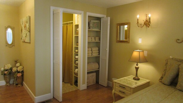 A bedroom with a bed, a nightstand with a lamp, a dresser, a closet with open doors, and a mirror on the wall. - Elegant & Spacious Home!! 5 Bed & 3 Bath, 15 min. to U of O, Sleeps 14, 174.00 (Creswell)