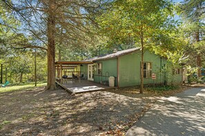 Un piccolo chalet con veranda, immerso tra gli alberi.