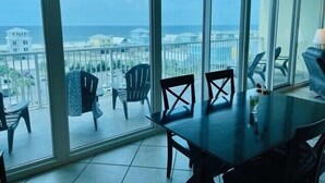 Un balcon avec vue sur l’océan et les bâtiments.