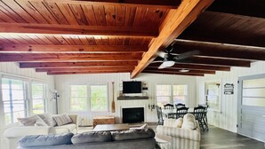 A spacious living room with a fireplace, a dining area, and a large window providing natural light.