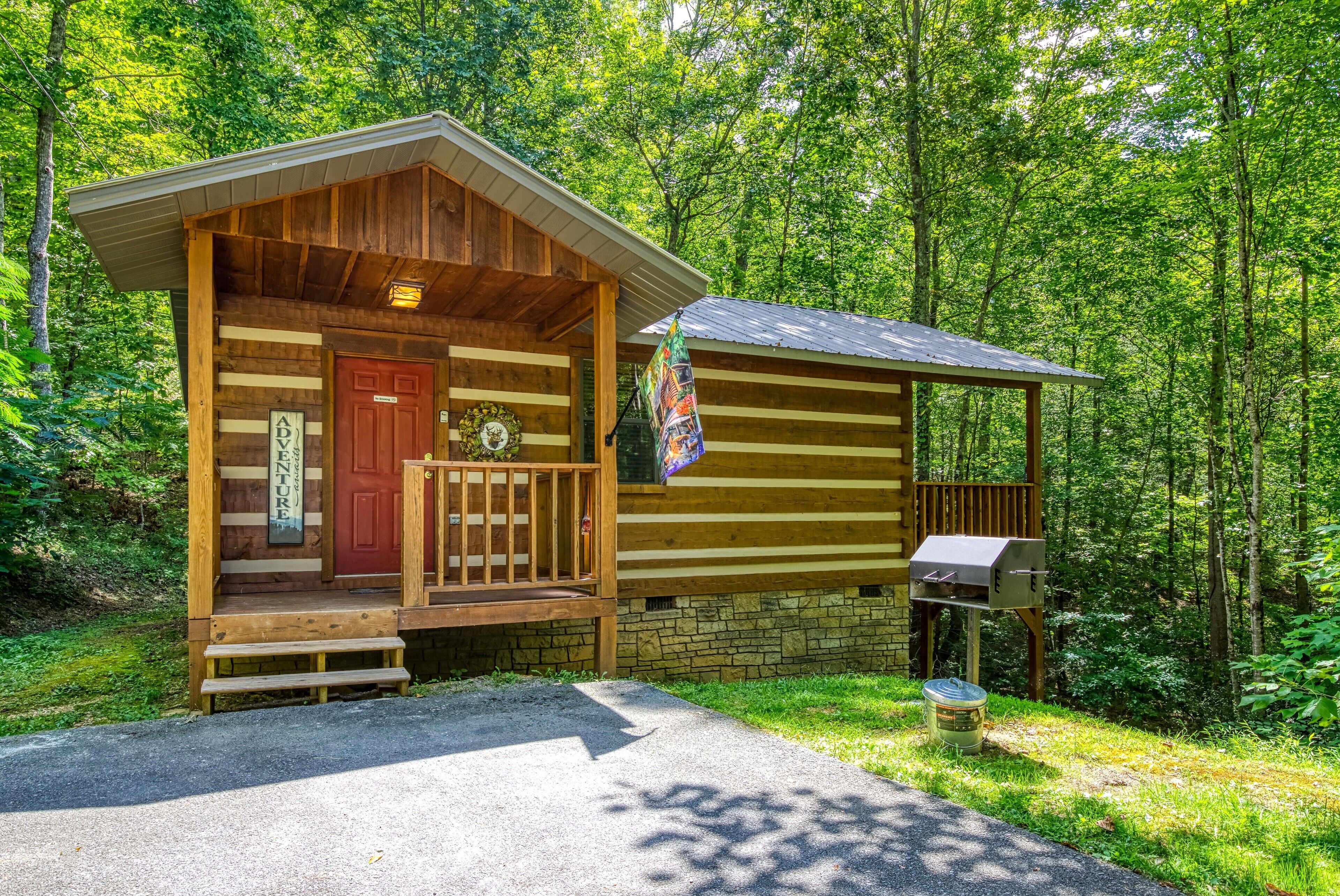A rustic cabin with a wooden exterior, a front porch, and a mailbox.