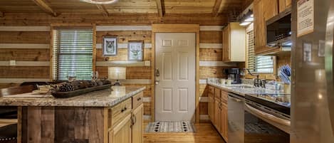 Cozy kitchen with a central island, wooden cabinets, and a stainless steel refrigerator.