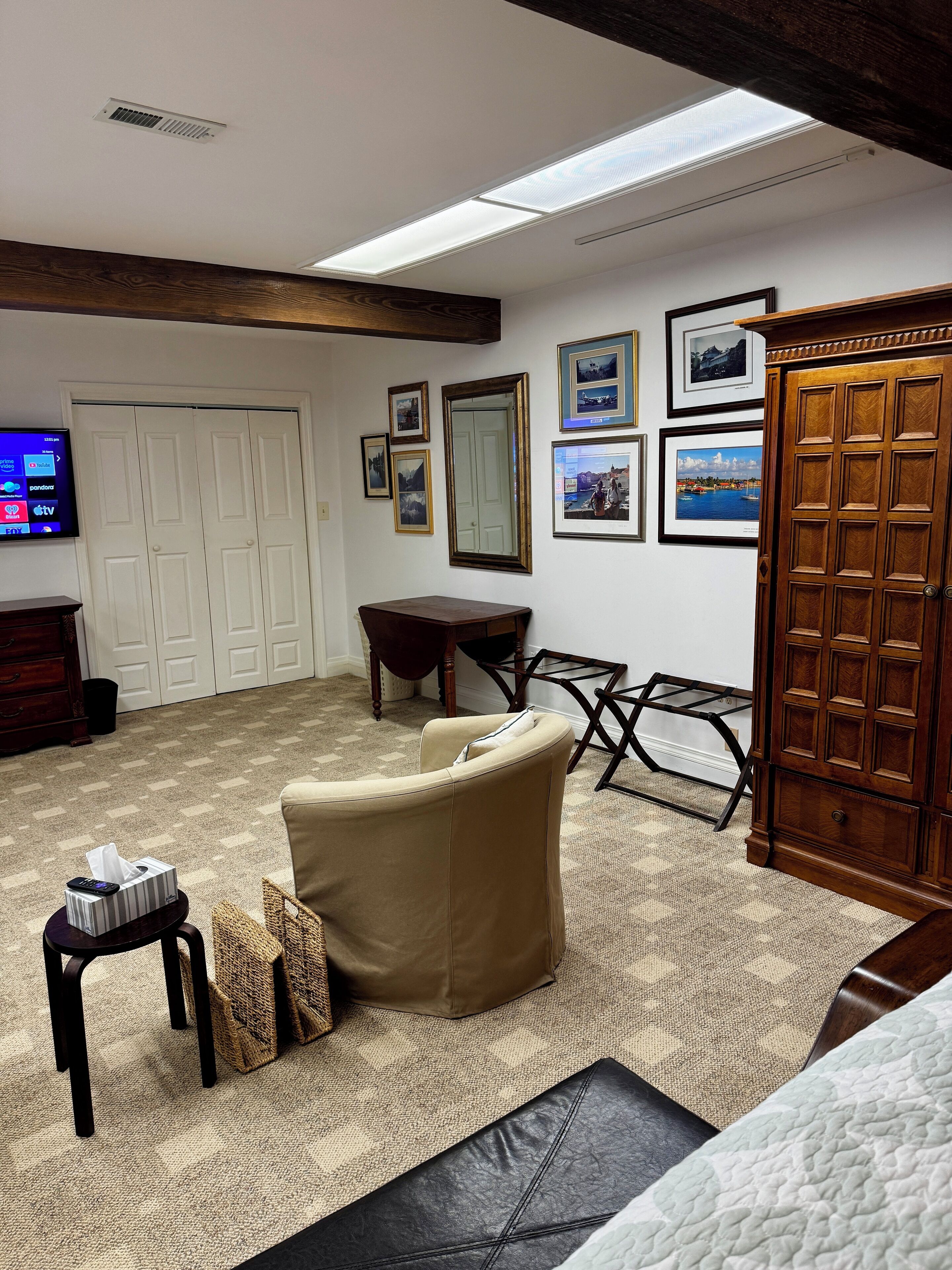 A living room with a sofa, a coffee table, a TV, and framed pictures on the wall.