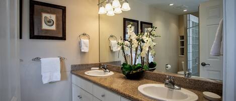 A bathroom with two sinks, a large mirror, and a framed picture on the wall.