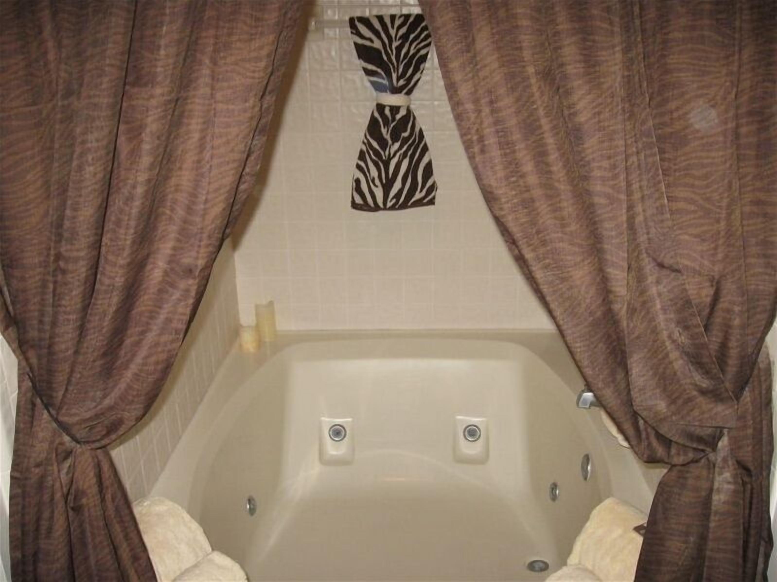 Une salle de bain avec une baignoire, deux robinets et un porte-serviettes.