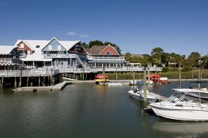 A waterfront property with a dock, a boat, and a building with multiple decks.