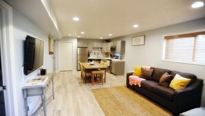 A compact living space with a dining area, kitchenette, and a sofa.