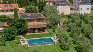 Une propriété résidentielle dotée d’une piscine, de panneaux solaires et d’un jardin bien entretenu.