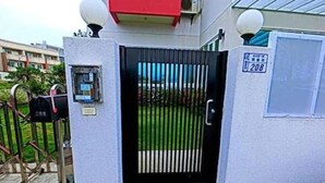 A gated entrance with a number sign, a mail slot, and a security camera. - Kinginn (Taitung)