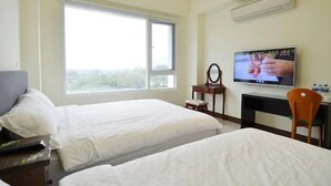 A hotel room with two beds, a TV, a desk, and a chair. - Kinginn (Taitung)