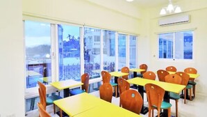 A hotel room with large windows, wooden furniture, and an air conditioning unit. - Kinginn (Taitung)