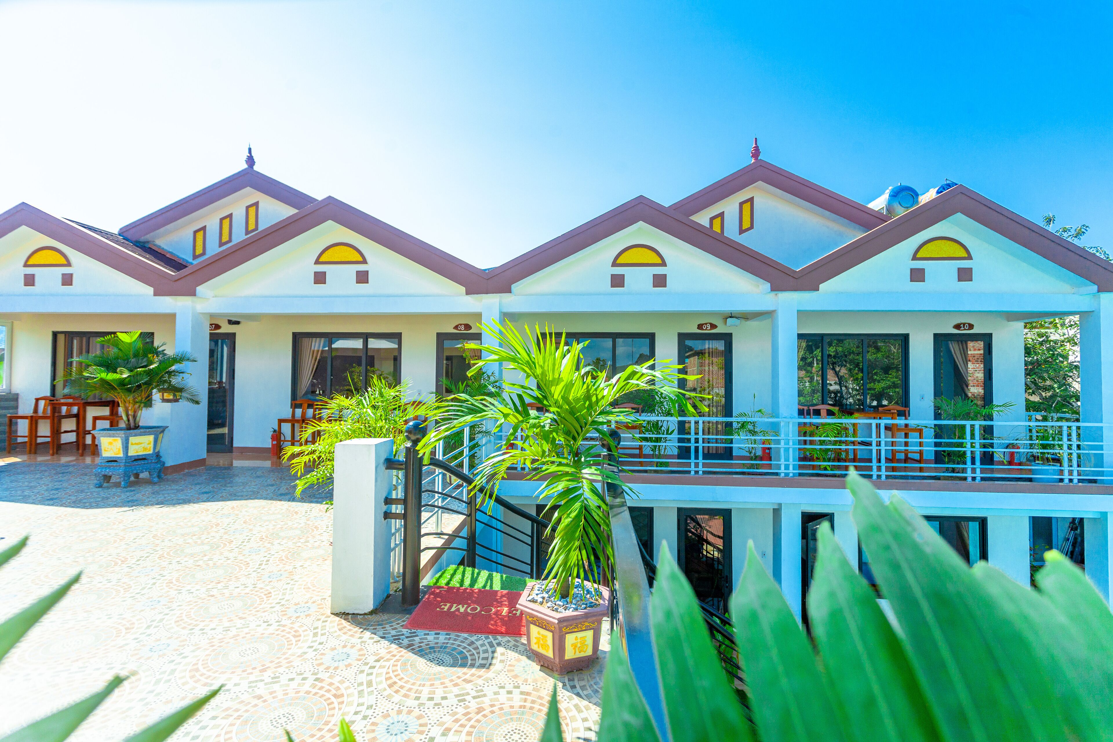 Un hotel con varias unidades, un área exterior techada y una piscina.
