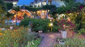 A residential area with multiple houses, a swimming pool, and a garden pathway. - Lucky Homes (Phong Nha)