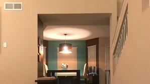 A hallway with a patterned rug, a bench, a table, and a refrigerator. - Westside El Paso Beautiful Big House lots of Perks contemporary nice Backyard (El Paso)