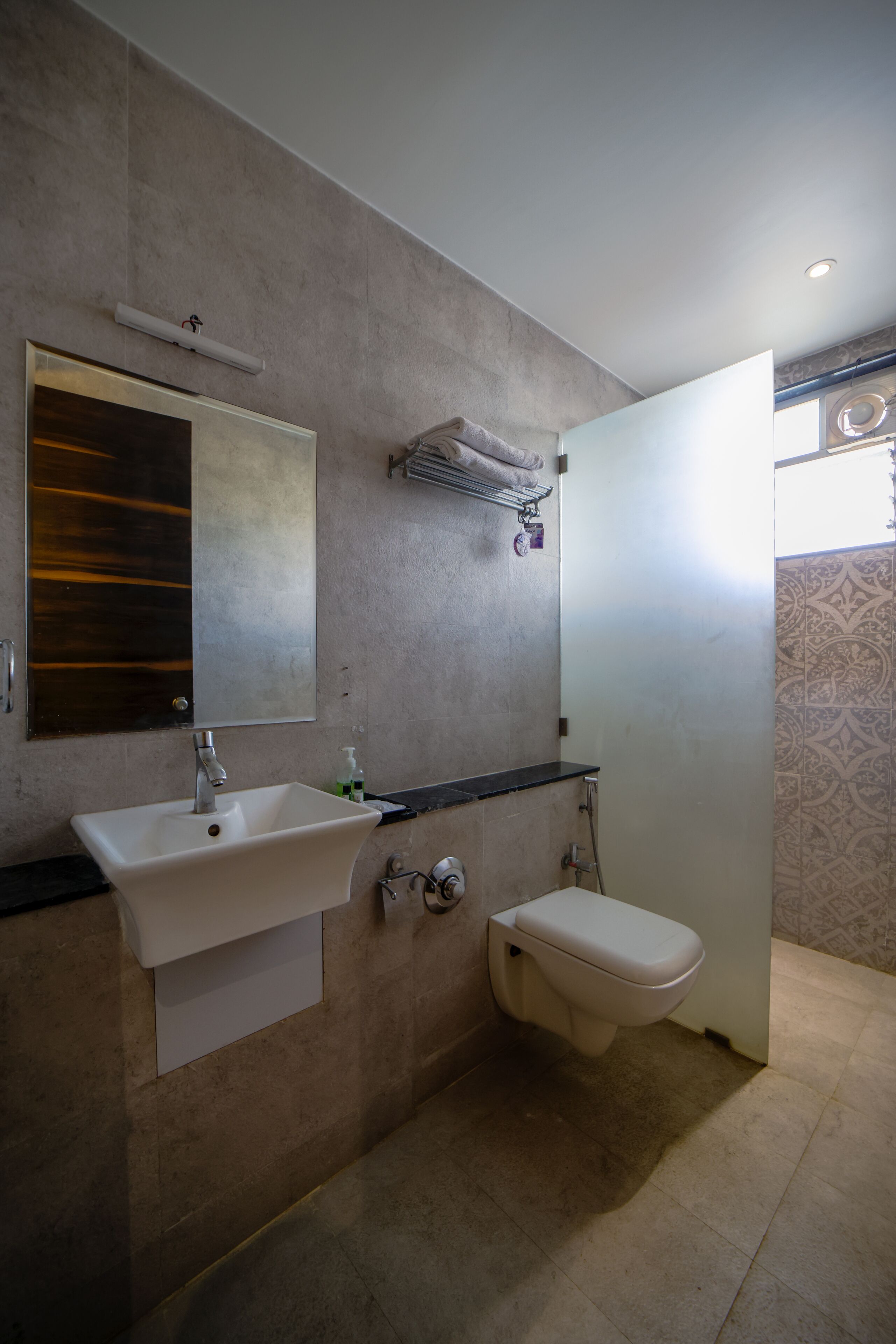 A bathroom with a white sink, a toilet, and a mirror.