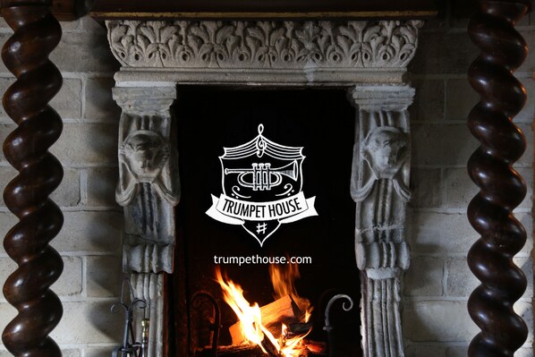 A fireplace with a decorative emblem and a website address.