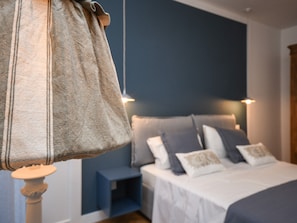 Une chambre à coucher avec un lit, des oreillers et un sac suspendu.