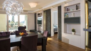 A modern dining area with a wooden table, purple chairs, and a fruit bowl. - Flowers Dubrovnik Luxury Apartments (Dubrovnik)