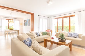 A spacious living room with a sofa, coffee table, and dining area.