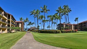A hotel with multiple floors, a central pathway, and palm trees.