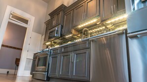 A modern kitchen with stainless steel appliances, wooden cabinets, and under-cabinet lighting.