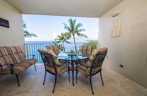 Enjoy ocean views from this balcony with a glass-top table and four comfortable chairs.