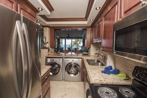 Enjoy cooking in this well-equipped kitchen with a refrigerator, stove, and washer and dryer.