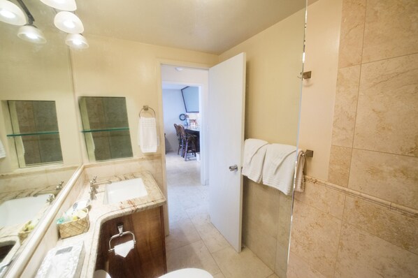 Een badkamer met een bad, een wastafel, een spiegel en een douchehoek.