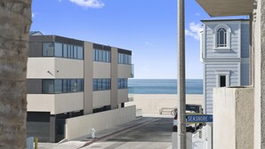 En modern byggnad med utsikt över stranden, en brandpost och en skylt med texten ”Seashore Drive”.