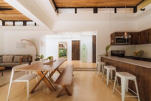 Une cuisine moderne avec des meubles en bois, un four à micro-ondes et une planche de surf.
