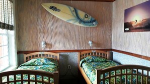 A room with two wooden beds, a surfboard on the wall, and a painting of a surfer. - In the HEART of Ocean Drive in North Myrtle Beach (North Myrtle Beach)