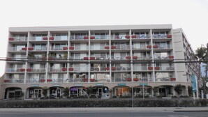 A multi-story hotel with balconies, a ground-level restaurant, and a visible sign for a bicycle rental service. - #605 Top Floor Unobstructed Ocean View/Sunsets,  New quiet A.C. (Kihei)